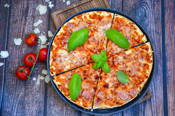  Close up of    hot italian pizza   classic ham. Fresh basil,tomato sauce ,mozzarella cheese , mushrooms and  minced meat .Concept poster for Restaurants or pizzerias. Top view