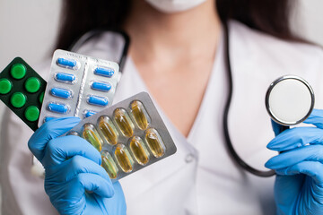 Doctor close up holding white pills for weight loss
