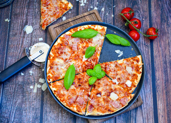  Close up of    hot italian pizza   classic ham. Fresh basil,tomato sauce ,mozzarella cheese , mushrooms and  minced meat .Concept poster for Restaurants or pizzerias. Top view