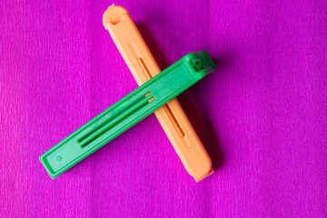 green and orange plastic closure for bags on purple