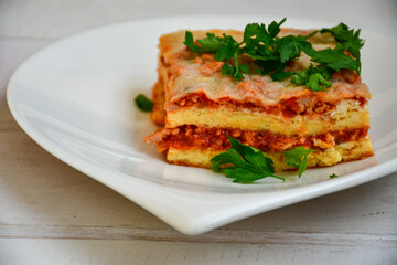   Delicious Home made keto diet  Lasagna bolognese  with  Lupin Flour, minced meat,tomato sauce and spinach  on a wooden rustic  background.Home made low carb italian meal