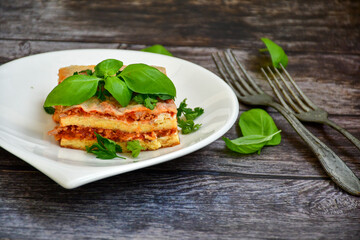   Delicious Home made keto diet  Lasagna bolognese  with  Lupin Flour, minced meat,tomato sauce and spinach  on a wooden rustic  background.Home made low carb italian meal