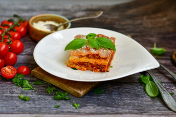   Delicious Home made keto diet  Lasagna bolognese  with  Lupin Flour, minced meat,tomato sauce and spinach  on a wooden rustic  background.Home made low carb italian meal