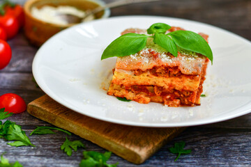   Delicious Home made keto diet  Lasagna bolognese  with  Lupin Flour, minced meat,tomato sauce and spinach  on a wooden rustic  background.Home made low carb italian meal