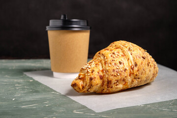 Croissant and coffee. Takeaway breakfast