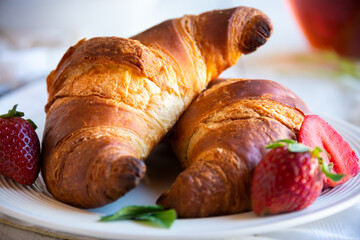Croissants with strawberry jam and fresh fruit, delicious and healthy breakfast