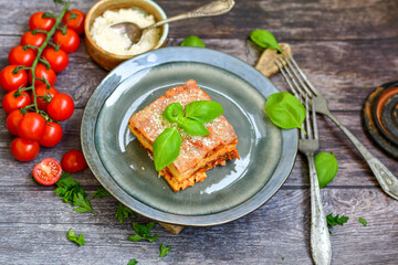   Delicious Home made keto diet  Lasagna bolognese  with  Lupin Flour, minced meat,tomato sauce and spinach  on a wooden rustic  background.Home made low carb italian meal