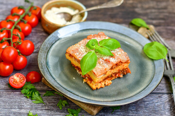   Delicious Home made keto diet  Lasagna bolognese  with  Lupin Flour, minced meat,tomato sauce and spinach  on a wooden rustic  background.Home made low carb italian meal