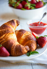 Croissants with strawberry jam and fresh fruit, delicious and healthy breakfast