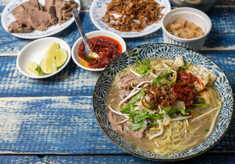 Malaysian soup noodles or locally know as Bihun Sup Utara with ingredients. Selective focus.
