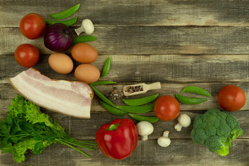 On the table are products for an omelet with lard and vegetables. Place for text