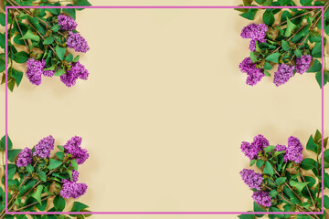 Purple lilac branches on  beige paper background. Greeting card with place for your text.