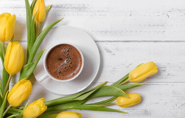 yellow tulips, a cup of black coffee on a white wooden background, gift, flowers, top view