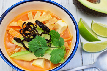 伝統的なメキシコのスープ　ソパ・デ・トルティージャ（ソパ・アステカ）ライムとアボガドを添えて　Traditional Mexican soup Sopa de tortilla (Sopa Azteca,Mexican Tortilla Soup) served with lime and avocado　