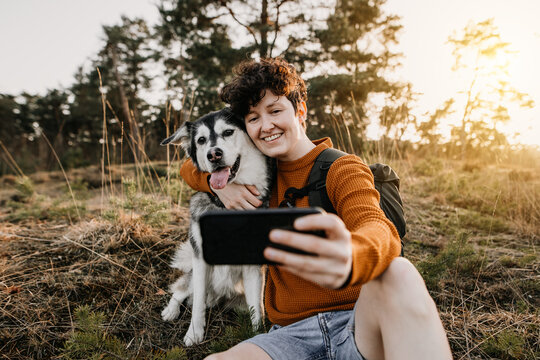 Mensch und Hund machen Selfie in der Natur 