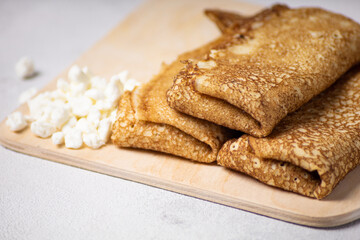 Pancakes roll on a light background close-up