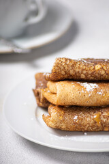 Pancakes roll on a light background close-up