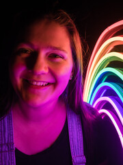 A girl light by a rainbow