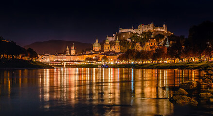 Fototapeta na wymiar Fantastic colorful evening view on Salzburg historical city. Castle Hohensalzburg with night street light and perfect reflection. concept ideal resting place. Popular travel and historical center.