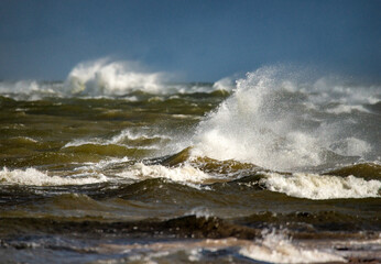 Storm clouds above the Baltic sea in winter. Dramatic sky, waves and water splashes. Dark seascape. Latvia.
