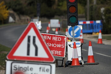 Country lane road work temporary traffic lights and signs