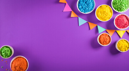 Happy holi festival decoration.Top view of colorful holi powder on purple  background with copy space for text.