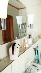 Bathroom details, clean white washbasin with mirror and lighting