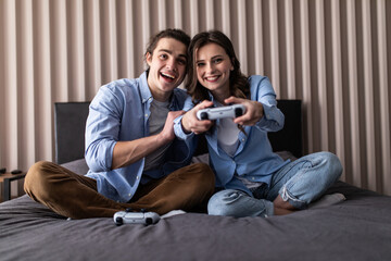 Young cheerful couple play to video game on a couch