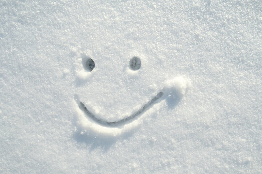 Face contented, cute smiley face drawn in the snow on a sunny winter day. Copy space. 
