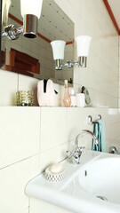 Bathroom details, clean white washbasin with mirror and lighting