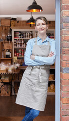 Portrait Of Female Owner Standing In Doorway Of Delicatessen  Food Shop