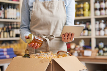 Close Up Of Female Owner Of Delicatessen Food Shop With Digital Tablet Preparing Online Grocery...