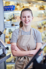 Portrait Ot Teenage Girl Working In Delicatessen Food Shop As Job Experience