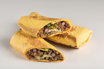 Tortilla roll with beef beans and fresh herbs on a white background, isolated.