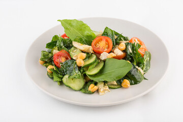 Summer salad of chicken and fresh vegetables: cucumber, cherry tomato, corn and spinach on a white background, isolated.