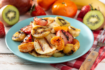 GRILLED FRUIT on a blue plate and white wooden table