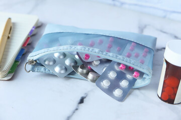 Close up of pills of blister pack in a small bag on white background 