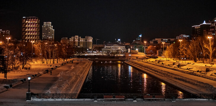 Yekaterinburg, Russia. Iset river embankment, Historical square, Plotinka, modern office buildings with evening illumination.