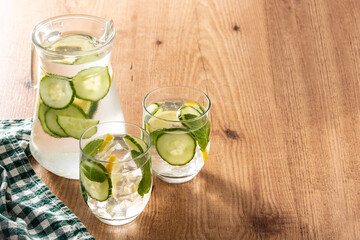 Sassy water or water with cucumber and lemon on wooden table. Copy space	