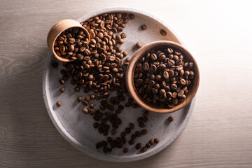 Dark Coffee Beans in a wooden Cup. Symbolic image. Rustic wooden background. Close up. Copy space.