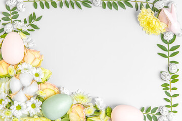 Creative layout composition of flowers and easter eggs on pastel background.
