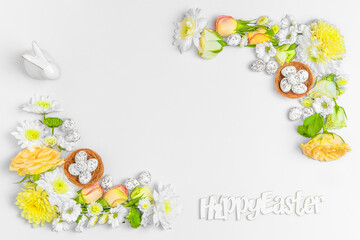 Creative layout composition of flowers and easter eggs on pastel background.