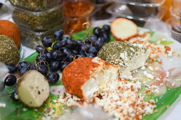 Tasting soft cheese with spices and grapes at the food fair