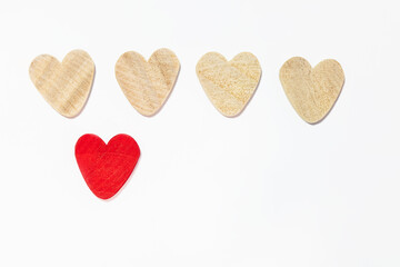 Fototapeta premium four wooden hearts, one red heart. isolated on white background. concept of unique feelings
