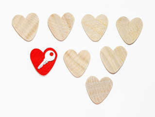 eight wooden hearts, one red. rows. isolated. concept of the key to the heart