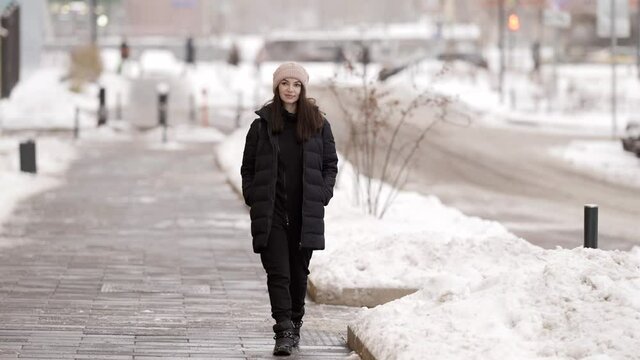 young townswoman is walking at winter day, casual dressed lady is strolling in outskirts