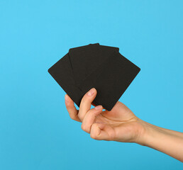 female hand holding a stack of blank black business cards