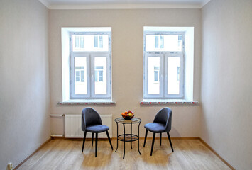 Modern interior design concept. Minimalistic style. Two blue armchairs and a table with fruit.