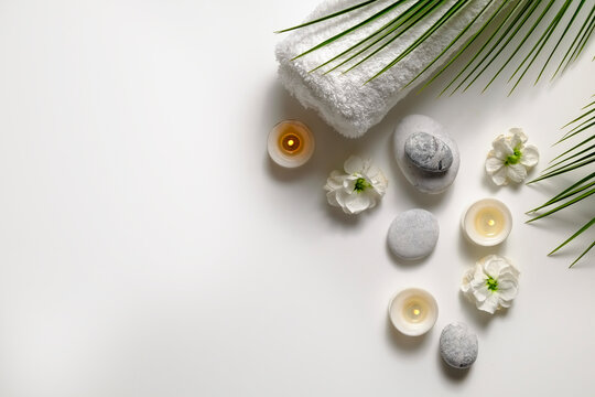 Composition with symbolic objects for spa salon. Stone therapy attributes for cosmetic procedures. Conceptual image, rocks and flowers representing balance. Close up, copy space, top view, background.