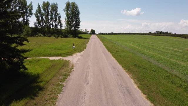 aerial Country Road in Leelanau County Michigan near Traverse City with apple and cherry orchards on a bright sunny day with a clear sky, some clouds and bright green grass